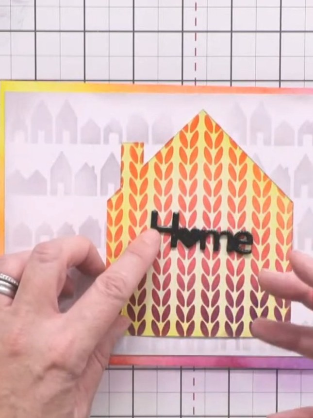 Step 9: Die-cut the word 'home' from black card three or four times. Layer the die-cuts together and seal with clear e
