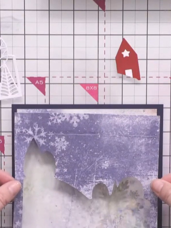 Step 7: Adhere the blue landscape aperture panel over the patterned paper base, ensuring the winter scene is centred w