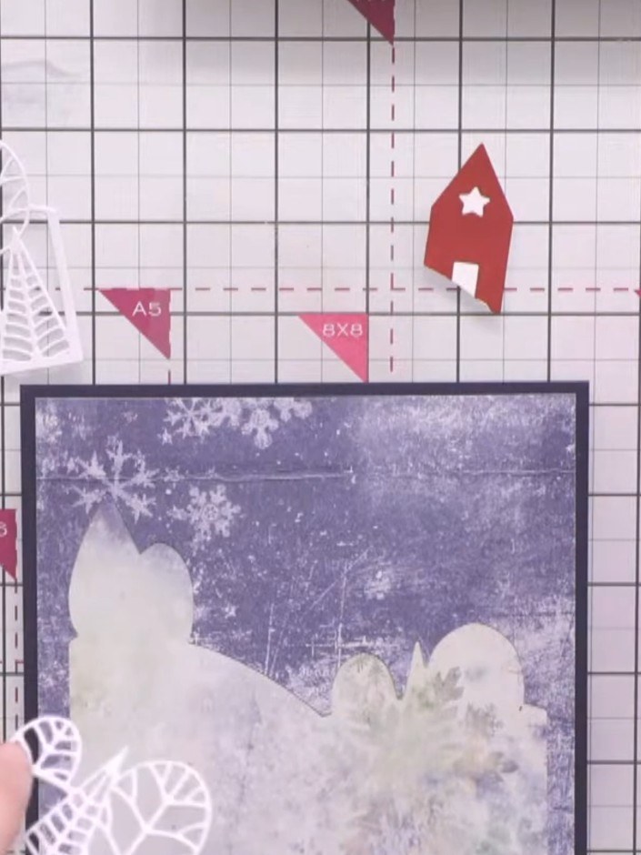 Step 9: Using a brush, apply embossing ink selectively onto the white die-cut trees and landscape elements. Paint the 