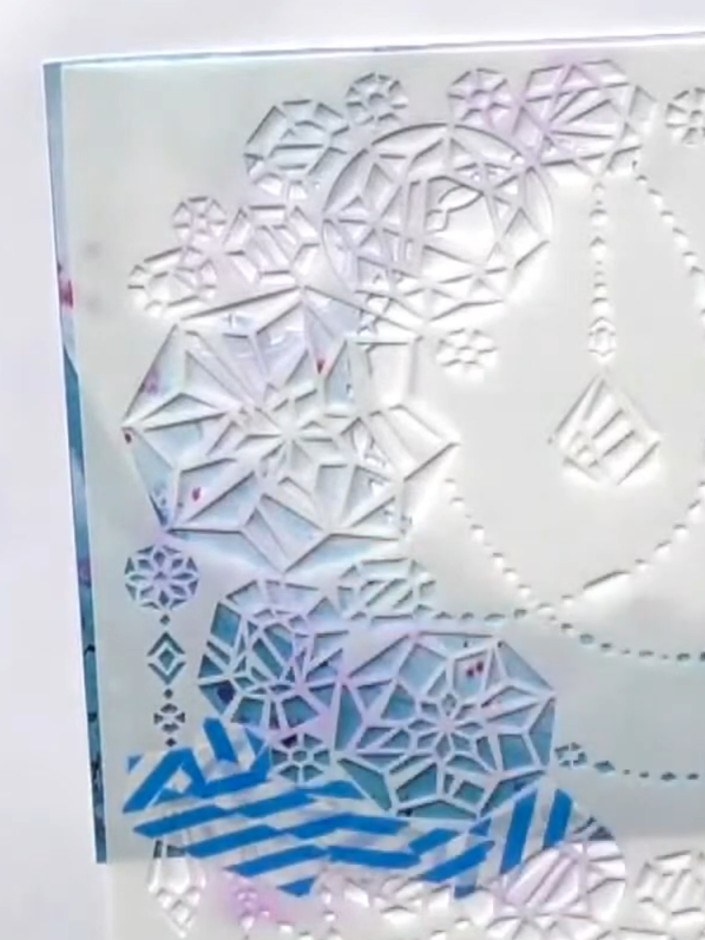 Step 3: Position a stencil over the aperture area on your card. Using a palette knife, apply white crackle paste throu