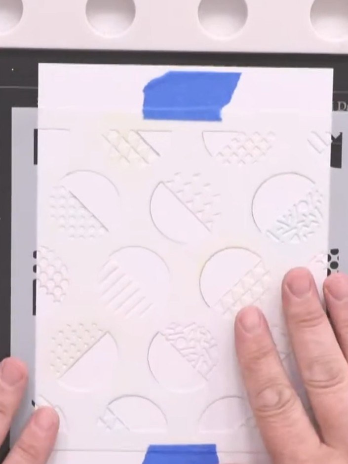 Step 1: Position the Retro Dots stencil on your white card base. Secure the stencil in place with masking tape at the 