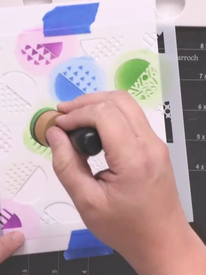 Step 3: Use the stencil to fill in multiple circles across the card with different colours. Vary between green, blue, 