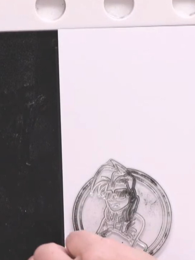 Step 10: Apply black embossing powder over the stamped character image. Heat with a heat gun until the powder becomes g
