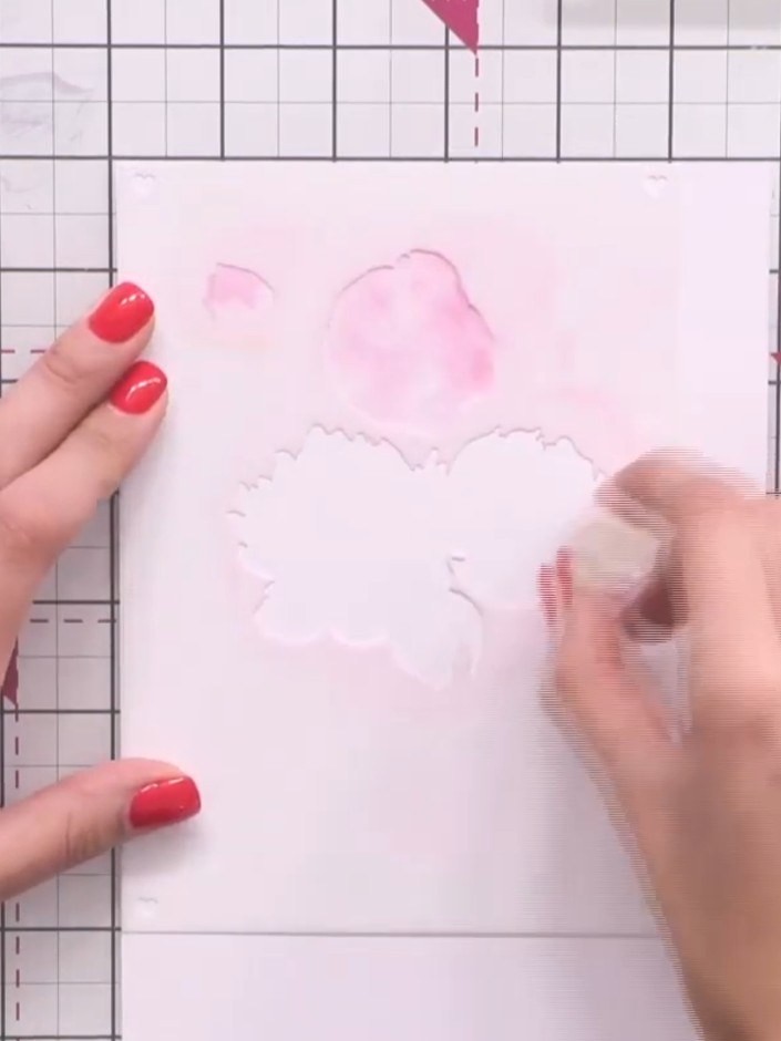 Step 2: Using a sponge dauber or brush, apply pink ink through the first stencil onto your card base. Lay down a subtl