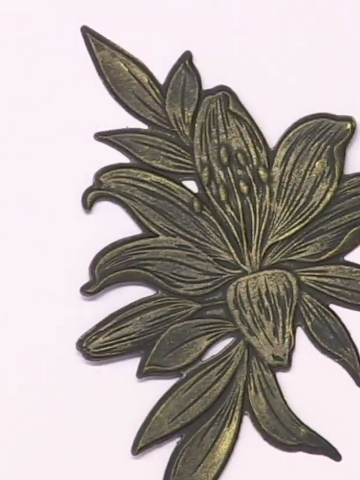Stap 10: Using a small brush or sponge, lightly apply gold paint over the embossed lily design. Work in small sections 