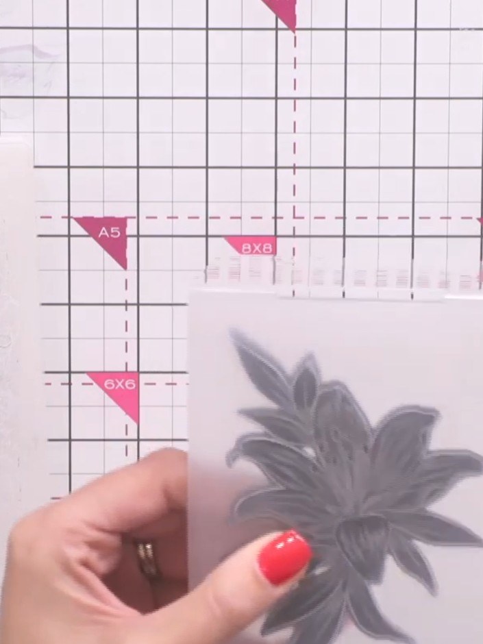 Stap 7: Place your embossed cardstock and the embossing folder with the lily design into your die-cutting machine. Run