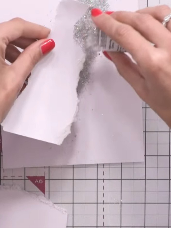 Stap 9: Sprinkle Litter Bug embossing powder generously over the inked snow edges on your card. Ensure all the wet ink
