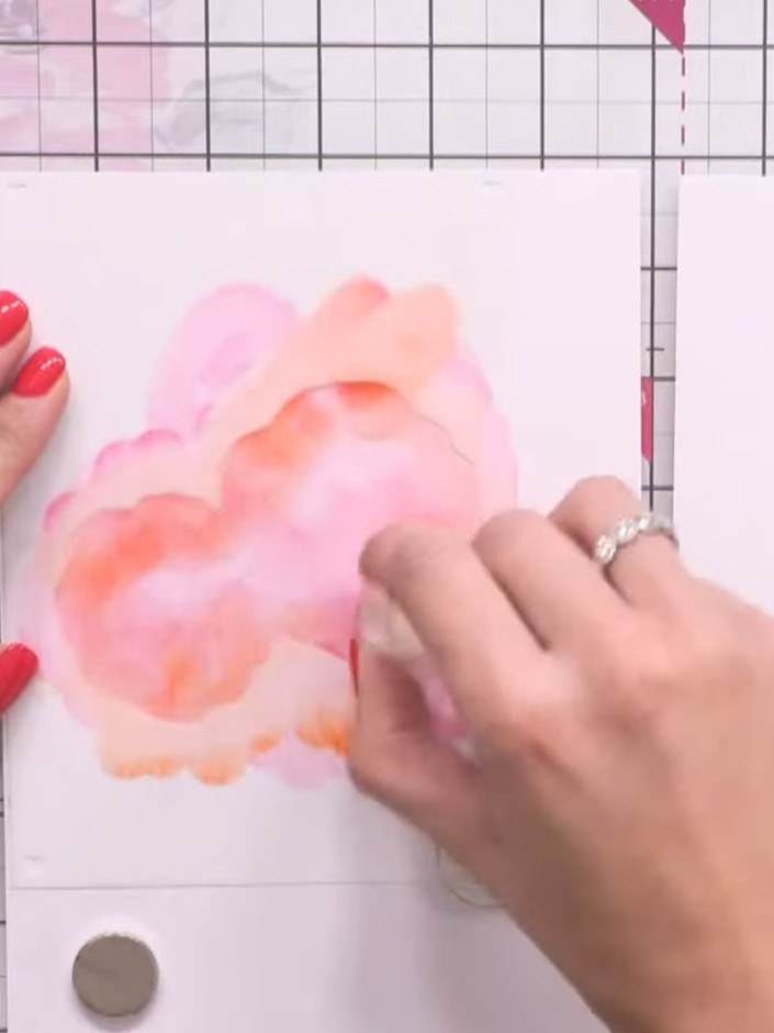 Passo 4: Add touches of orange ink around the edges and centre of the stencilled flower layer to create colour variatio