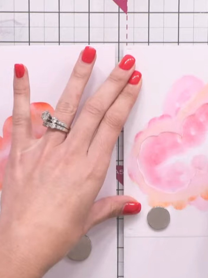Passo 5: Move to the second card and repeat the stencilling process using magenta and orange inks to create a watercolo