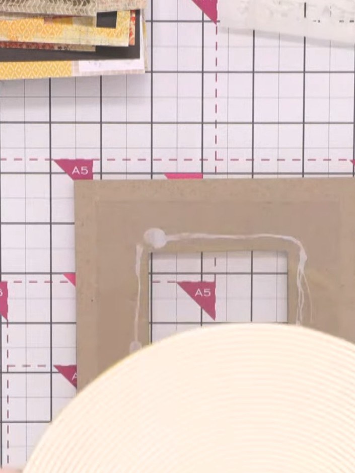 Passo 8: Apply foam tape around the edges of the kraft frame to create dimension. This will lift the frame above the ca