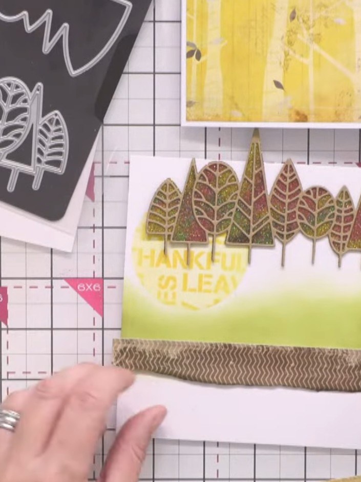 Passo 10: Tear strips of paper in coordinating colours. Apply glue only to the top edge of each strip and layer them ont