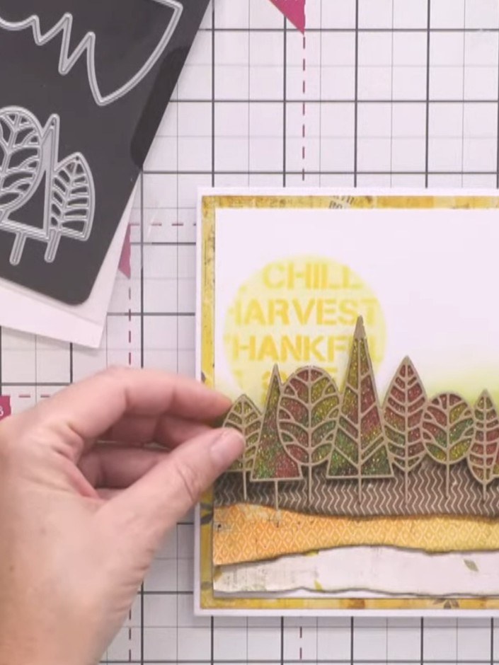 Passo 12: Apply foam tape to the reverse of the glittered tree die cut. Position and adhere the tree die cut in front of