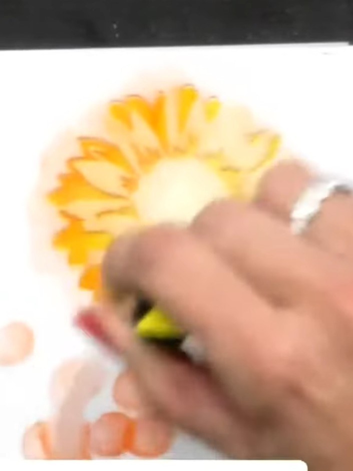 Passo 4: Position stencil three over the sunflower and apply green ink around the flower centre to add foliage and dept