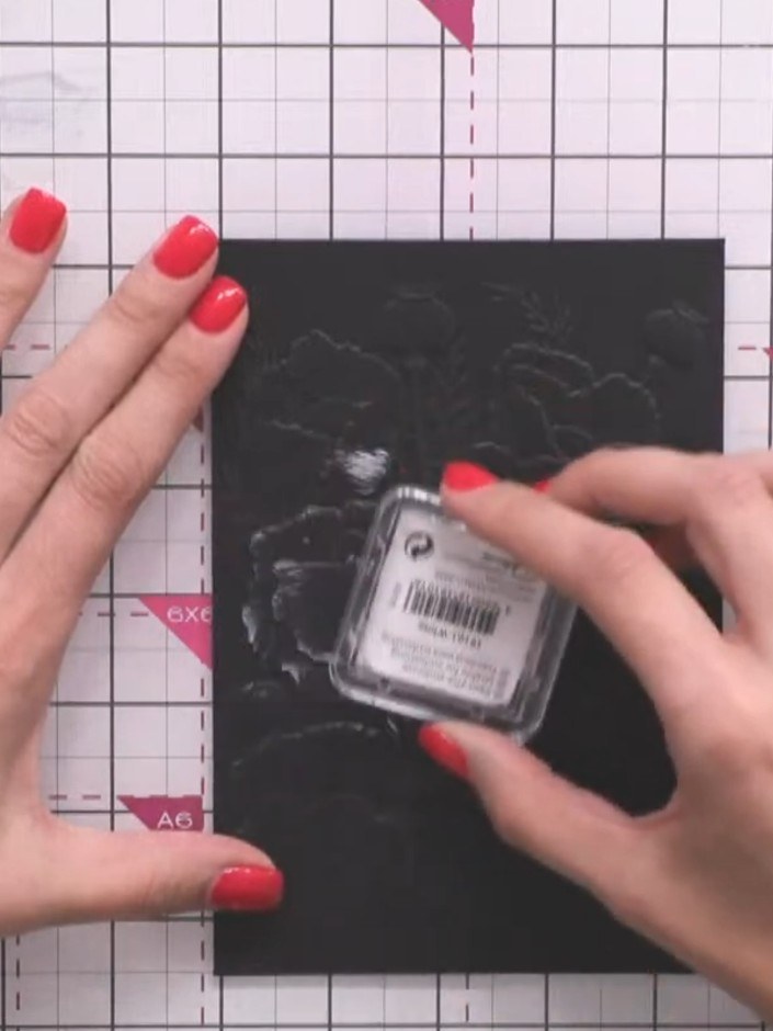 Paso 3: Apply white ink pad lightly over the embossed black card surface to highlight the dimensional details of the p