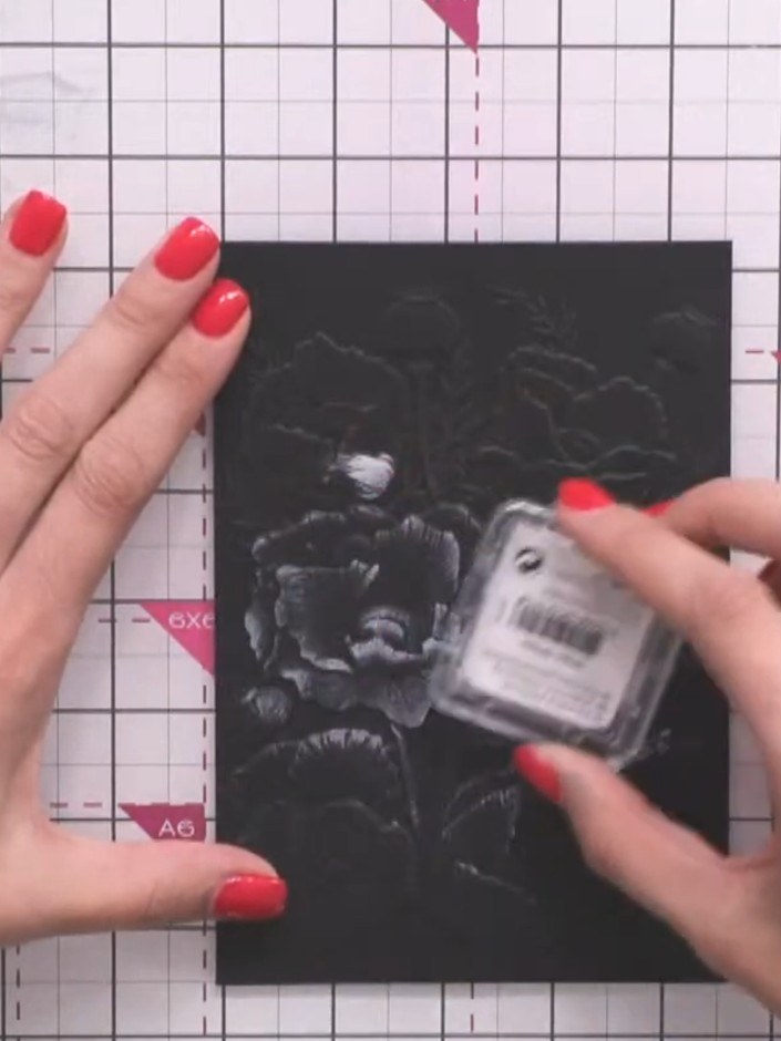 Passo 3: Apply white ink pad over the black embossed surface, dabbing gently to highlight the dimensional floral detail