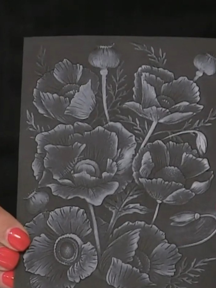Passo 5: Carefully cut out your embossed poppy design from the black cardstock, being mindful of the delicate raised el