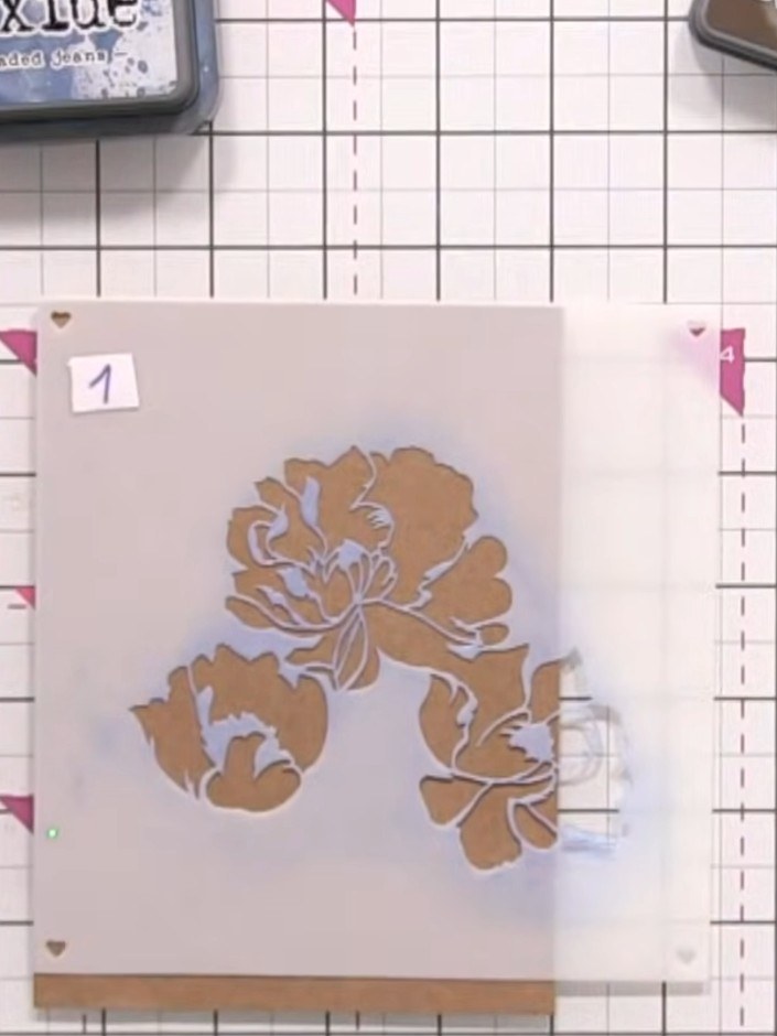 Step 2: Position your first layering stencil at the corner of your card, placing it half on and half off the page. Lig