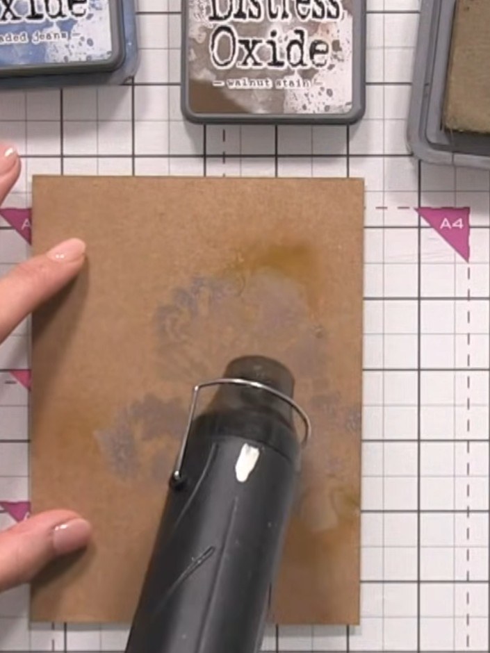 Step 5: Dry the sprayed area with a heat gun, moving it around to blend the water and ink together on the kraft card.