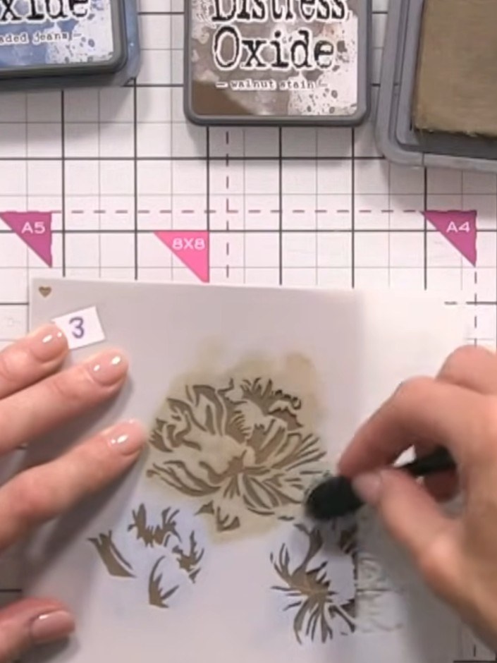 Step 7: Continue building up the floral design using stencil layers three and four. Press progressively harder with ea