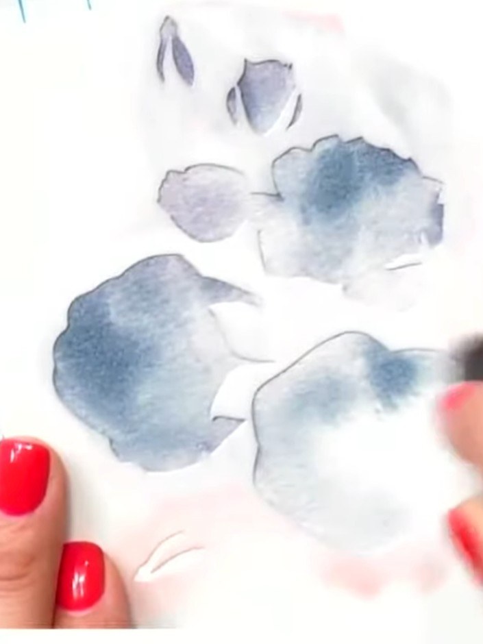 Passo 2: Lightly spray the inked stencil areas with clean water using a spray bottle to create a soft watercolour bleed