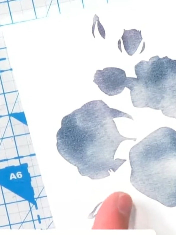 Passo 3: Allow the watercolour to bleed and spread naturally across the stencilled areas. If there is excess water pool