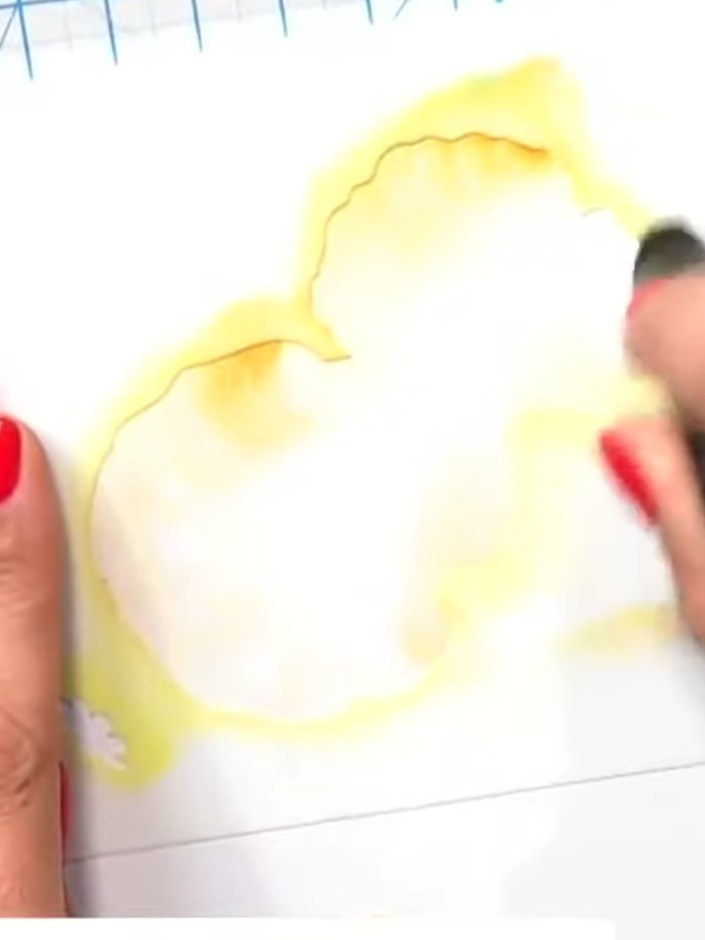 Passo 1: Position the poppy bunch stencil on your white cardstock. Using a blending tool with yellow ink, apply colour 