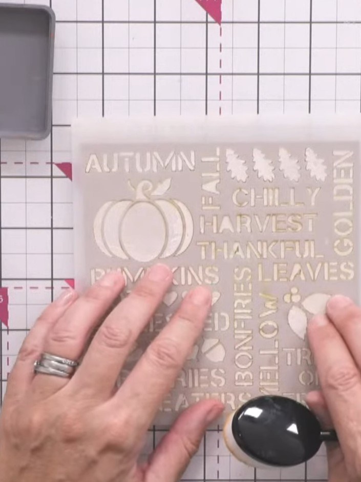 Passo 2: Once the texture paste is dry, place the autumn stencil back over it. Using a blending tool, ink over the sten