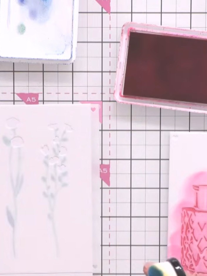 Step 7: Using the second vase stencil, apply a contrasting colour ink (blue) to create the second vase layer. Position