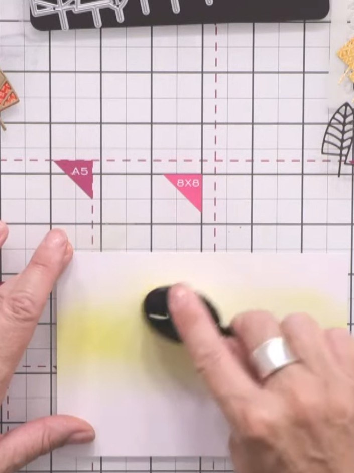 Stap 5: Using a blending brush, apply Fossilized Amber ink to the upper half of the card front, creating a warm backgr