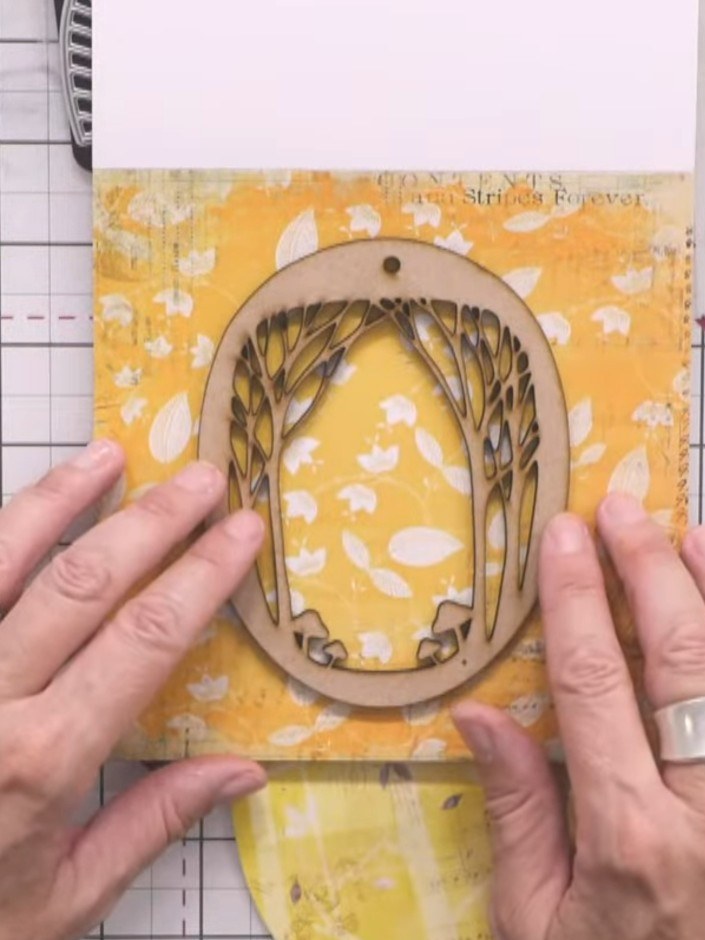Step 2: Leg das Forest Glade MDF-Overlay auf das gemusterte Papier und zeichne mit einem Bleistift leicht drumherum.