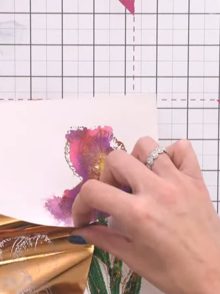 Stap 12: Gently burnish the foil with your finger to transfer the metallic finish onto the watercolour iris design. Wor