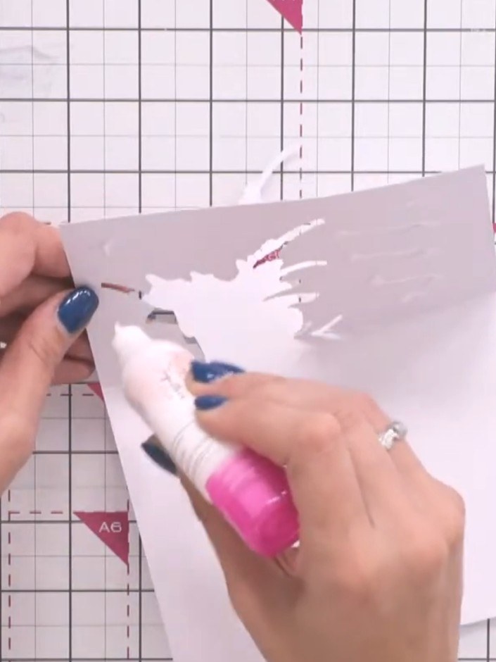 Stap 11: Apply foam pads to the back of the die-cut shaped piece and the embossed floral panel. Press down firmly to se