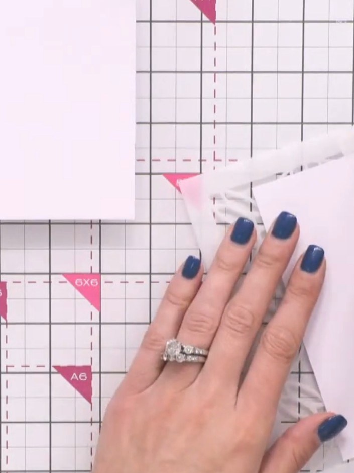 Stap 9: Position a stencil on the white cardstock layer and smooth it down with your hands. Lightly dust grey ink thro