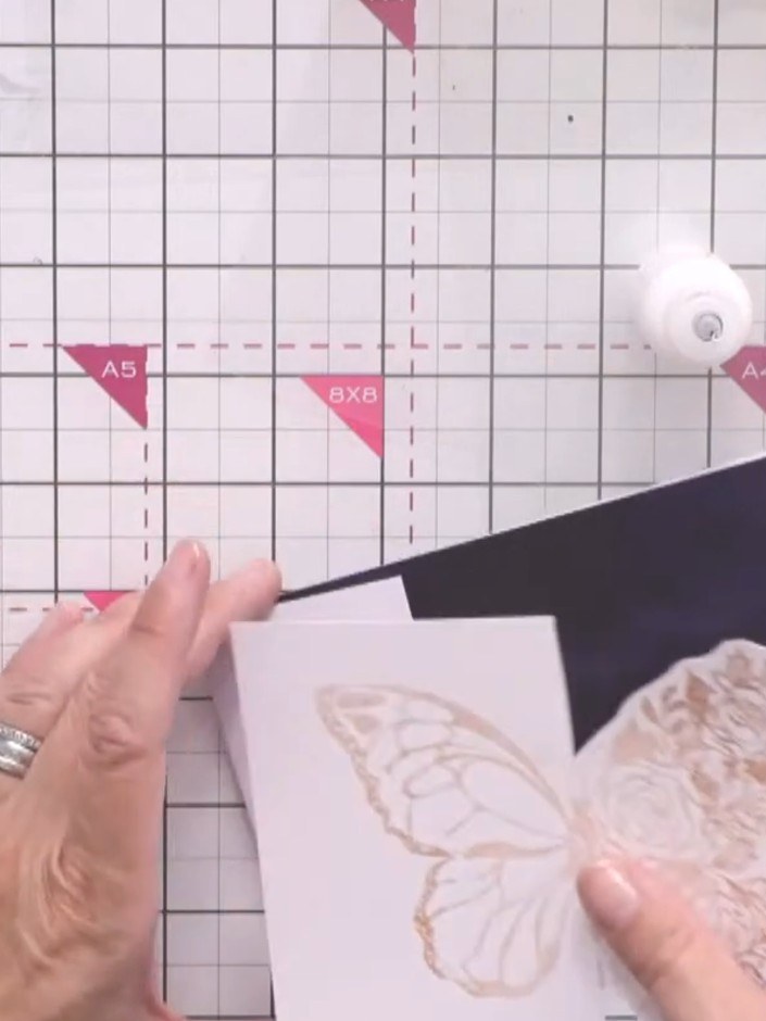 Passo 9: Adhere the blue shibori paper to the back of your card panel so it shows through the cutout butterfly wing. Th