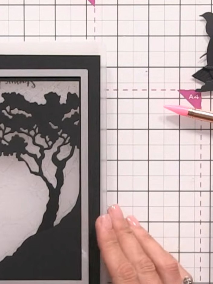 Step 8: Layer the black die-cut tree frame onto the ombre background paper, positioning it to frame the scenic element