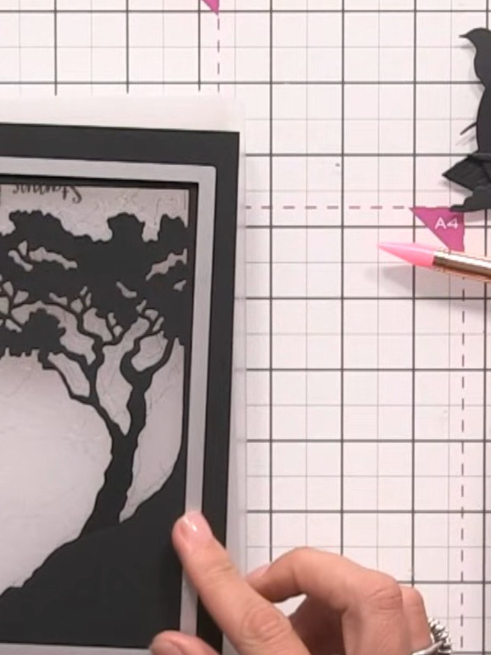 Step 9: Mount the completed layered tree frame piece onto a white card blank, ensuring an even white border is visible