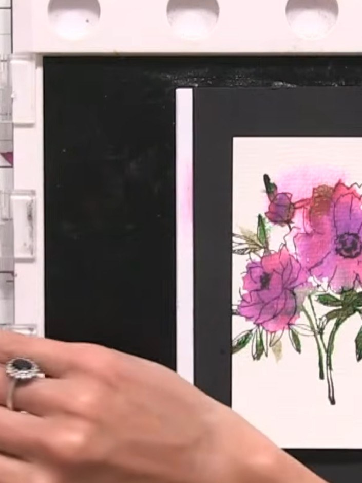 Step 11: Add a sentiment stamp to the bottom of the floral panel. Mount the completed panel onto a black card base to f