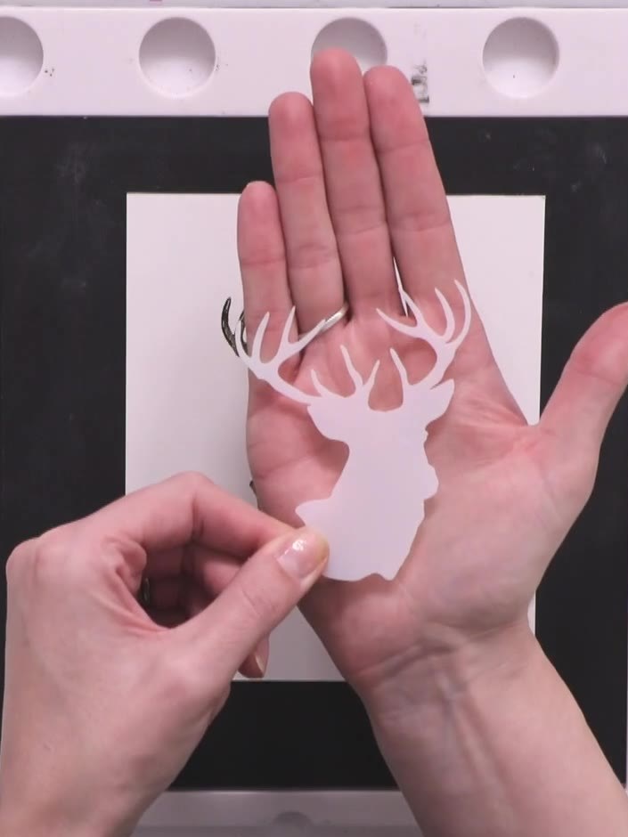 Step 3: Secure the plastic stag mask over the stamped and coloured stag image using low-tack tape to protect it whilst
