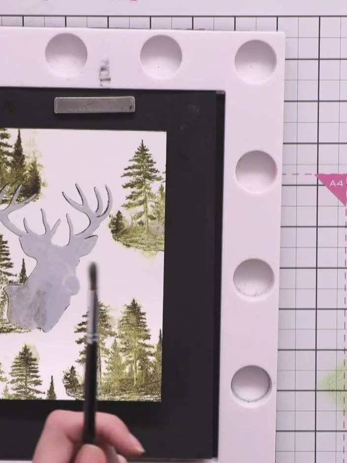 Step 7: Add splatter effects by mixing green and brown distress inks on your craft mat, spraying with water, and flick