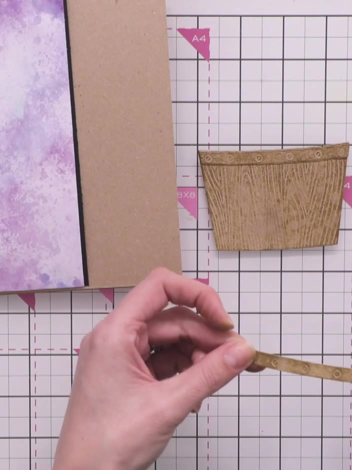Step 13: Apply adhesive to the back of the wooden crate piece and position it at the top of your purple watercolour pan