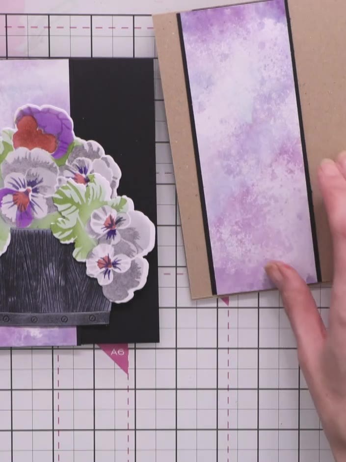 Step 14: Layer your die-cut pansies onto the wooden crate, using foam pads behind some flowers to create dimension. Arr