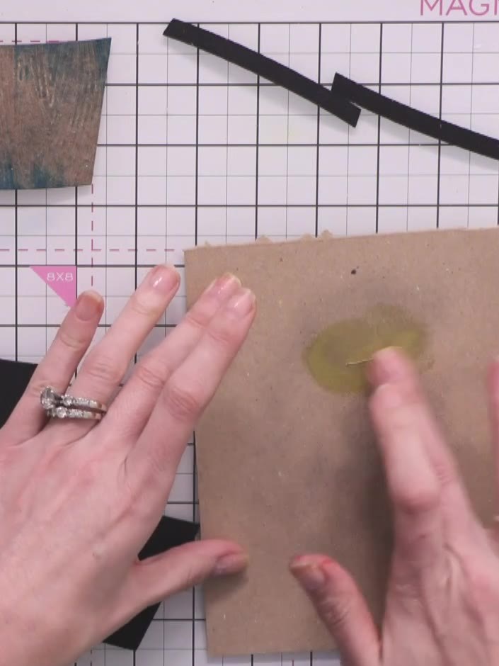 Step 5: Tap gold finger wax onto a piece of scrap card to remove excess. Swipe your finger across the kraft card crate