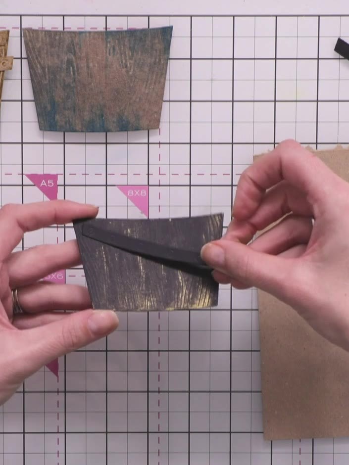 Step 6: Using your gold wax-coated finger, rub across the embossed details of the black wooden crate to highlight the 