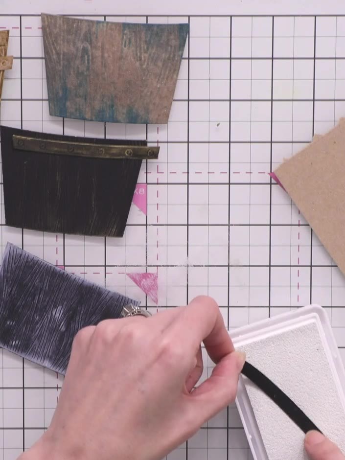 Step 8: Swipe a white ink pad across the embossed details of the fourth crate to highlight the texture and create a cl