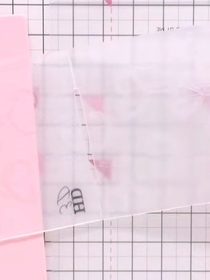 Step 3: Place your pink card stock face down onto the inked embossing folder and press firmly to transfer the design o