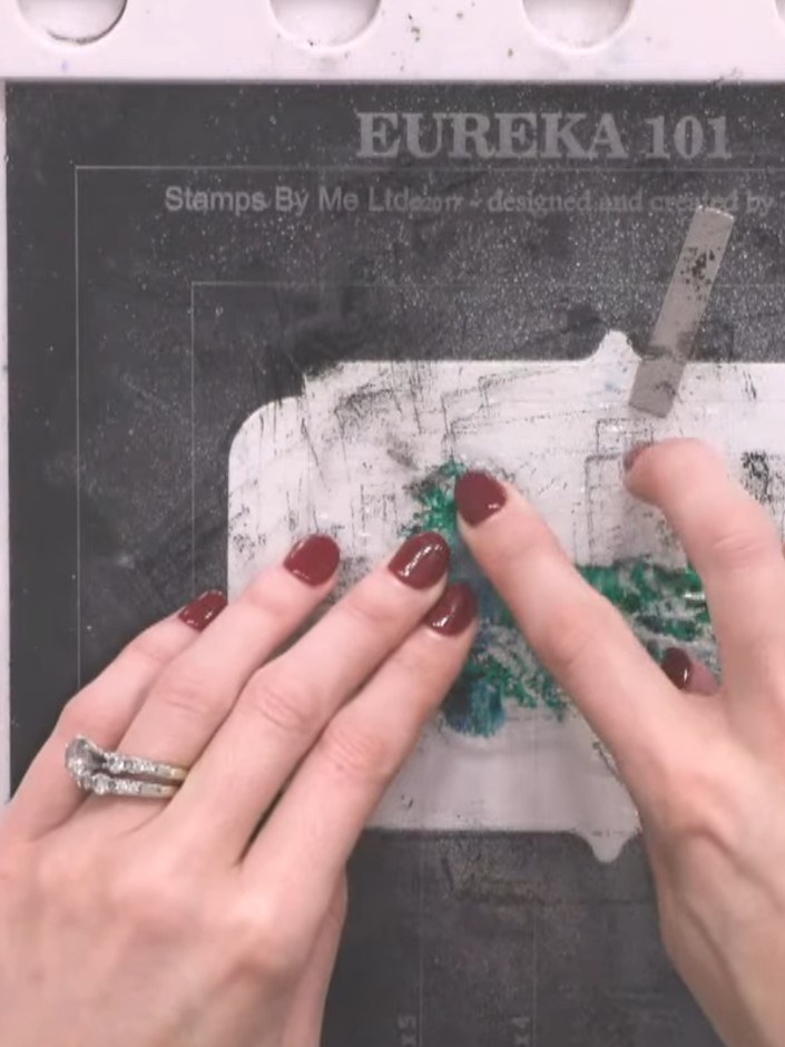 Step 5: Spray the stamped image with water two to three times. The water will cause the turquoise and teal colours to 
