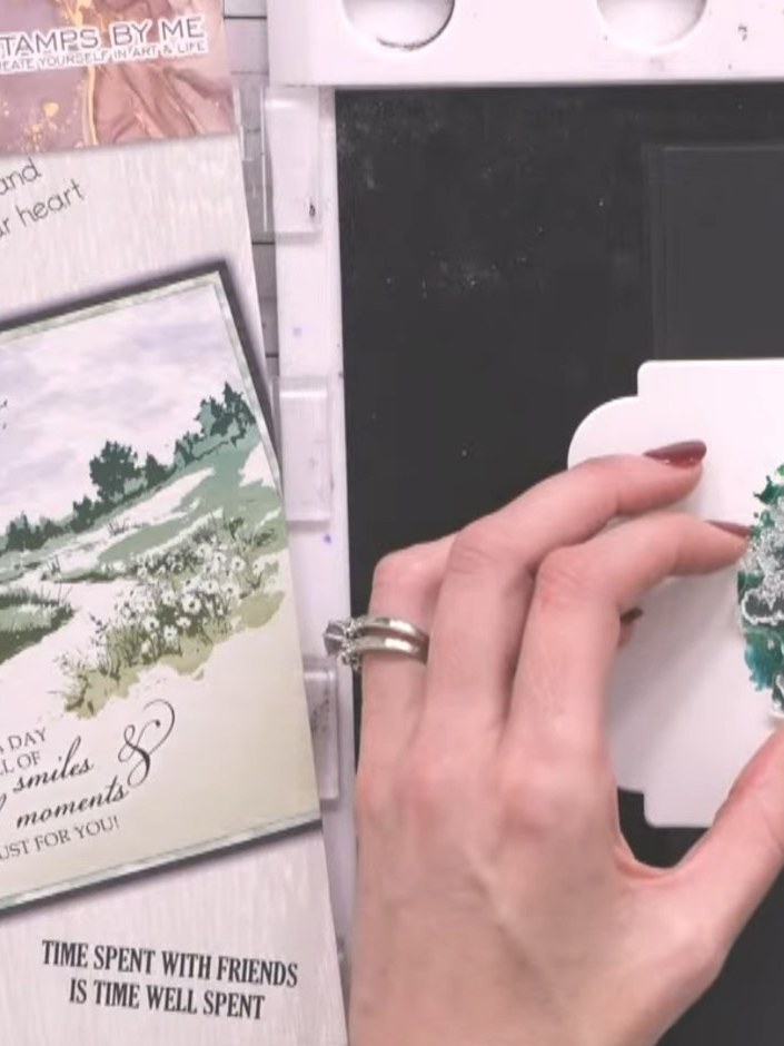 Step 9: Ink the detail stamp in black and press it down firmly over the landscape scene to add fine line work and text