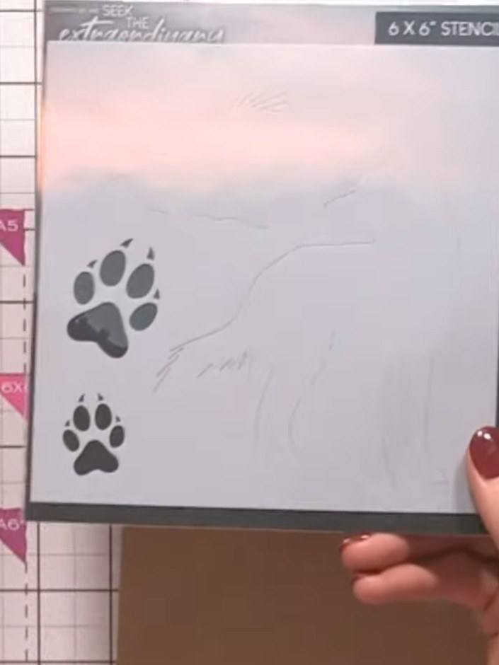 Step 1: Position the stencil onto your kraft card blank. Use an ink pad to tap through the stencil design, creating th