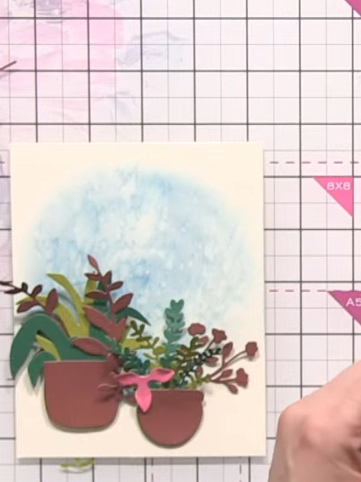 Step 10: Use a blending brush with blue ink to create a soft halo effect around the basket on your card background. App