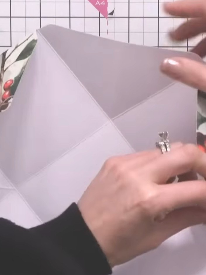 Step 8: Fold up the four sides of the box. Hook the eyelets on opposite corners together to close the box without usin